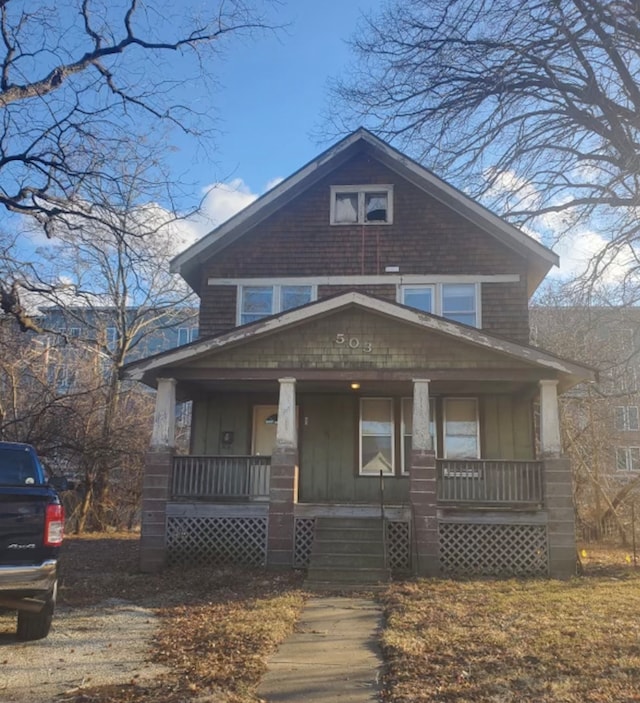 american foursquare style home featuring a porch and board and batten siding