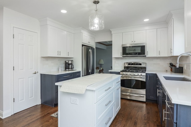 kitchen with dark wood-style floors, stainless steel appliances, light countertops, white cabinetry, and a sink