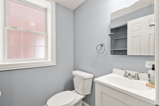 bathroom featuring a wealth of natural light, vanity, and toilet