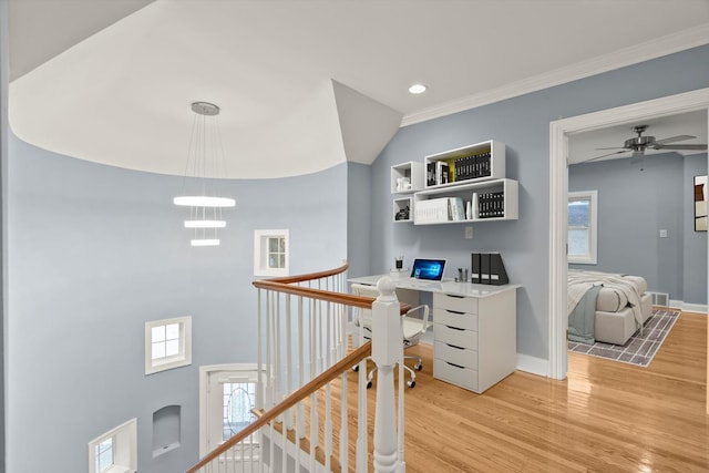 corridor featuring light wood-style floors, an upstairs landing, ornamental molding, and baseboards