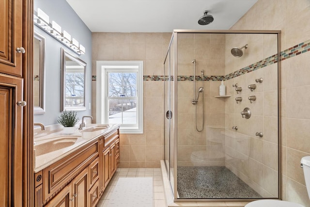 bathroom featuring a stall shower, tile patterned flooring, a sink, and toilet