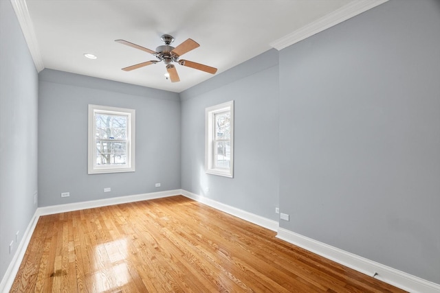 spare room featuring a ceiling fan, light wood-type flooring, ornamental molding, and baseboards