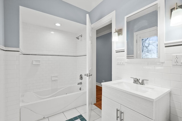 bathroom featuring tile patterned floors, bathtub / shower combination, tile walls, and vanity