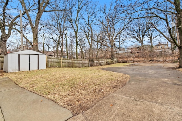 view of yard with an outbuilding, a storage unit, and fence