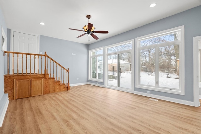 unfurnished living room with stairs, recessed lighting, light wood-style flooring, and baseboards