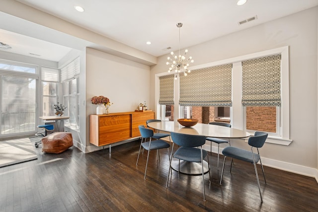 dining room featuring a chandelier, hardwood / wood-style flooring, recessed lighting, visible vents, and baseboards