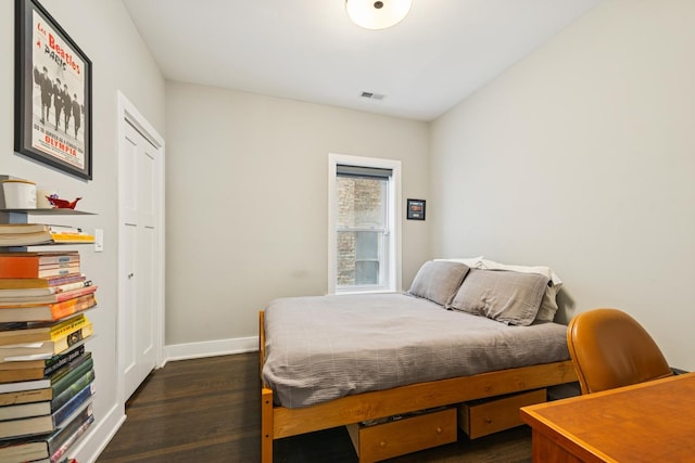 bedroom with dark wood-style flooring, visible vents, and baseboards