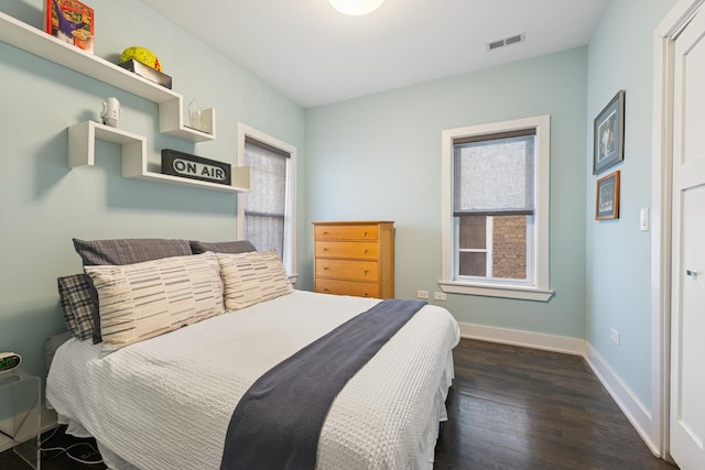 bedroom featuring wood finished floors, visible vents, and baseboards