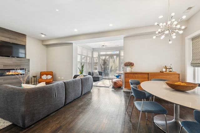 living area featuring visible vents, a tiled fireplace, hardwood / wood-style floors, a chandelier, and recessed lighting