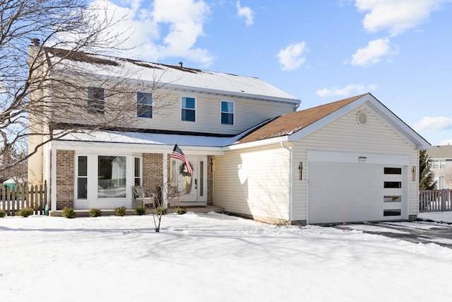 traditional-style house featuring brick siding, fence, and an attached garage