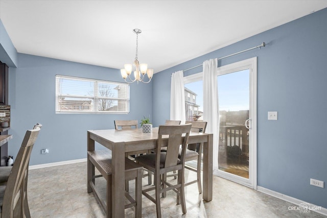 dining area featuring an inviting chandelier, a wealth of natural light, and baseboards