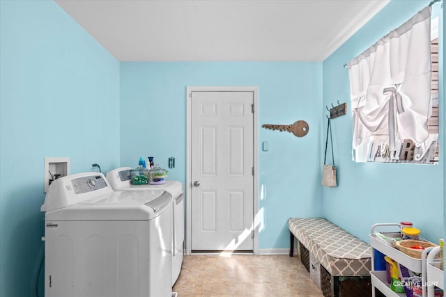 washroom with laundry area, washing machine and clothes dryer, and baseboards