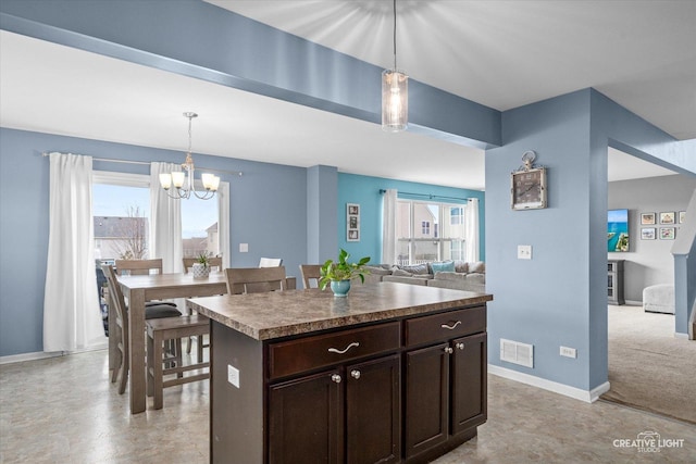 kitchen with a healthy amount of sunlight, an inviting chandelier, visible vents, and dark brown cabinets