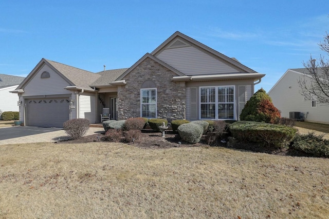 view of front of property featuring a front yard, central AC unit, a garage, stone siding, and driveway