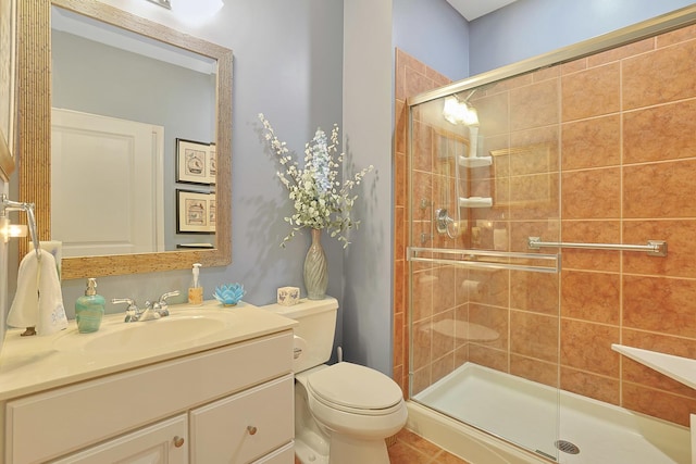 bathroom featuring vanity, toilet, and a stall shower