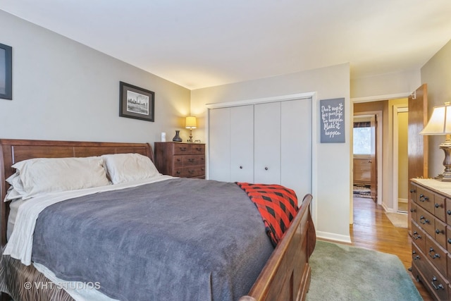 bedroom featuring a closet, baseboards, and wood finished floors