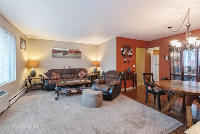 living room featuring a chandelier, baseboards, and wood finished floors