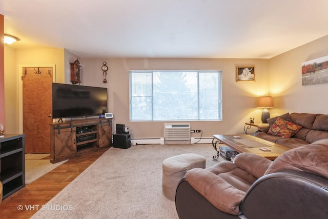 living area featuring a baseboard heating unit, a wall unit AC, and wood finished floors