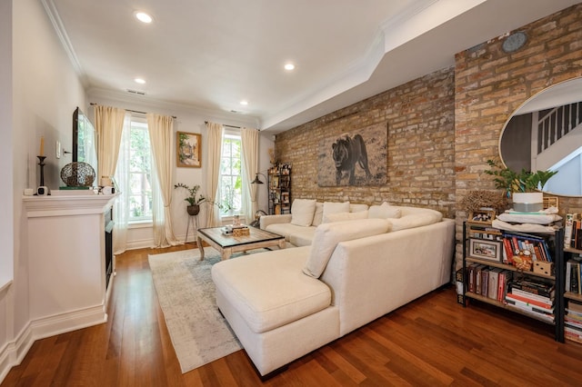 living area with brick wall, ornamental molding, wood finished floors, and recessed lighting