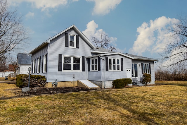 back of property featuring entry steps and a lawn