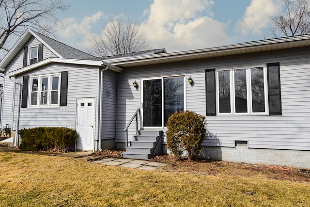 view of front of home with entry steps and a front lawn