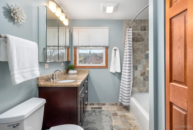 bathroom featuring toilet, visible vents, vanity, shower / tub combo with curtain, and stone finish floor