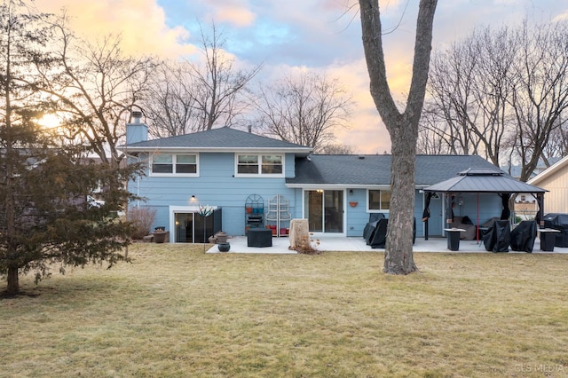 back of house with a gazebo, a yard, a patio, and a chimney