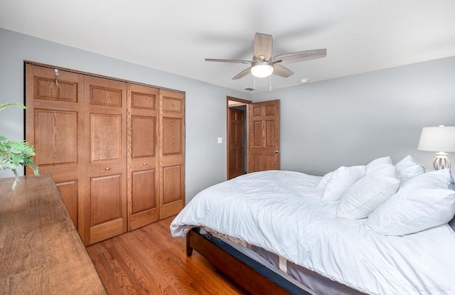 bedroom with light wood-style floors, a closet, visible vents, and ceiling fan