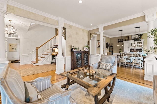 living area with a decorative wall, a wainscoted wall, decorative columns, and light wood-style flooring