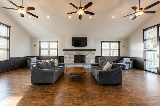 living room with a ceiling fan, wainscoting, and high vaulted ceiling