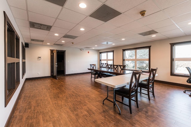 dining room featuring baseboards, dark wood finished floors, and a paneled ceiling