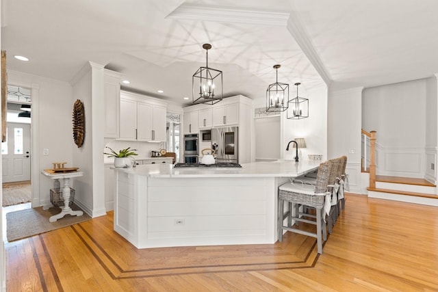 kitchen featuring light countertops, stainless steel appliances, an inviting chandelier, and a peninsula