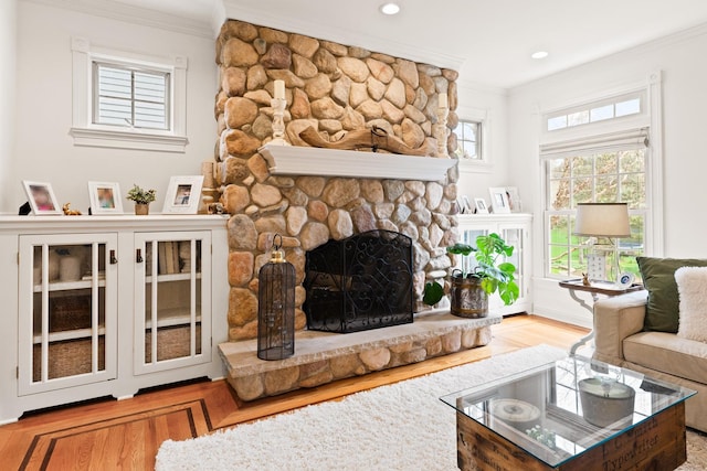 living area featuring recessed lighting, ornamental molding, wood finished floors, and a fireplace