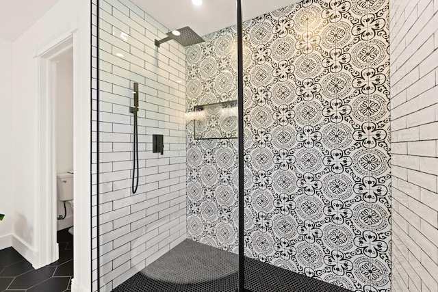 bathroom with a walk in shower, tile patterned floors, and toilet
