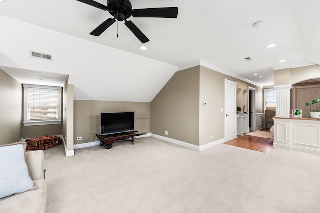 unfurnished living room with visible vents, light carpet, baseboards, ornate columns, and a ceiling fan
