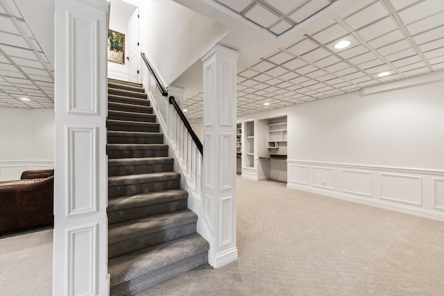 stairway featuring recessed lighting, carpet flooring, and a wainscoted wall