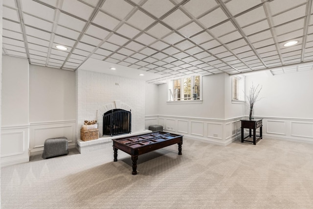 carpeted living area featuring recessed lighting, a decorative wall, and a fireplace