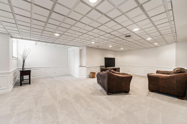 carpeted living room with recessed lighting, wainscoting, and a decorative wall