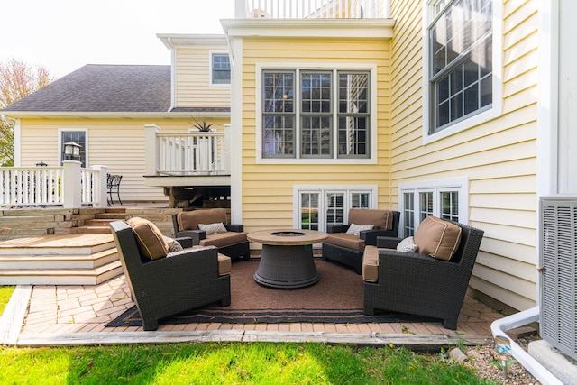 view of patio / terrace featuring a deck, cooling unit, and an outdoor living space with a fire pit