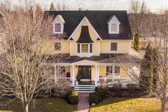 view of front of house with a porch and a shingled roof