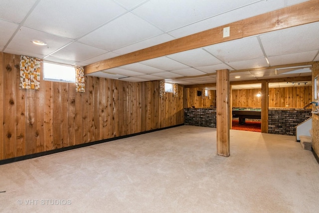 basement featuring pool table, wooden walls, a drop ceiling, and carpet floors