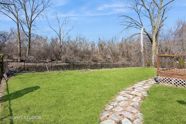 view of yard featuring a wooden deck and fence