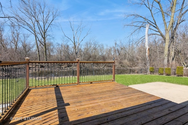 wooden deck featuring a lawn and fence