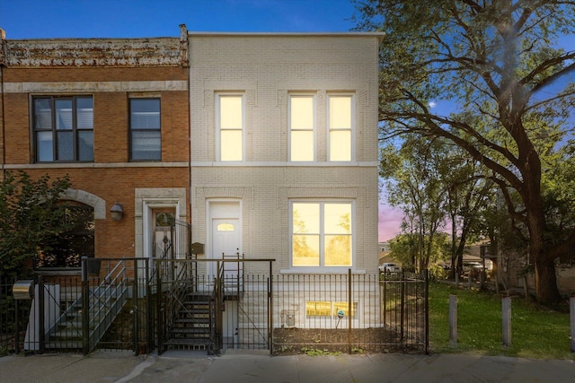 view of property featuring brick siding and a fenced front yard