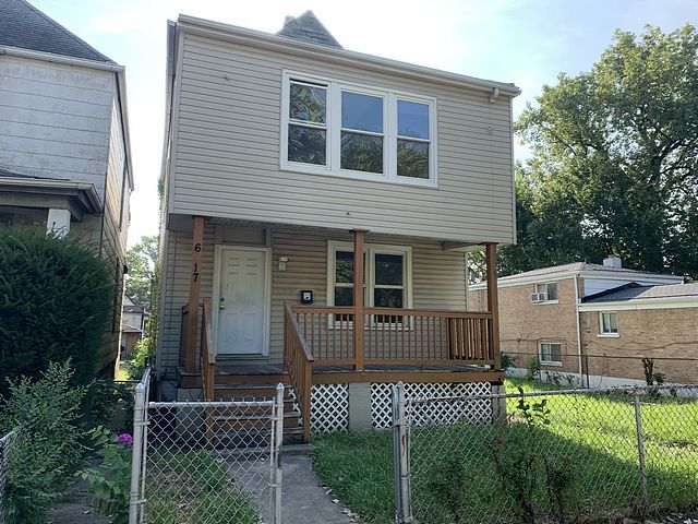 view of front facade featuring covered porch, a fenced front yard, a gate, and a front lawn