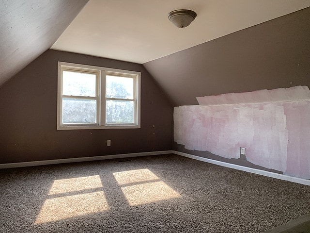 bonus room with carpet floors, vaulted ceiling, and baseboards