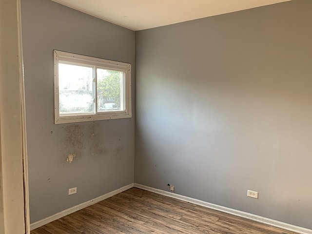 unfurnished room featuring wood finished floors and baseboards