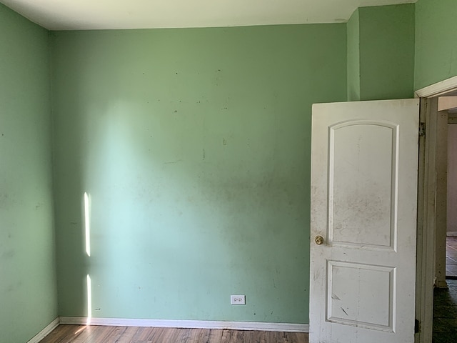 empty room featuring baseboards and wood finished floors