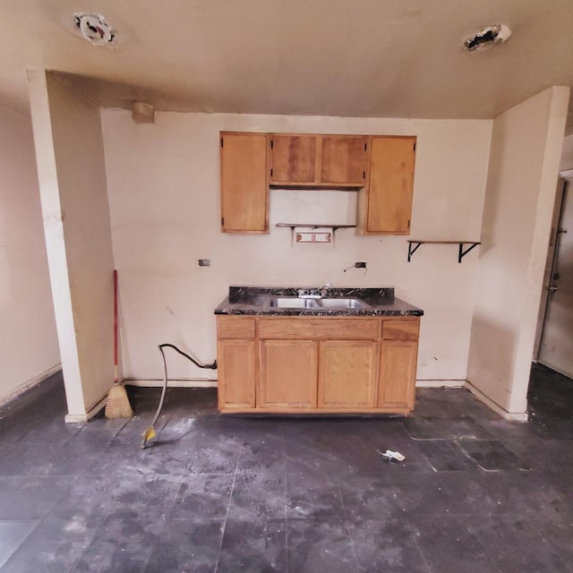 kitchen featuring dark countertops and a sink