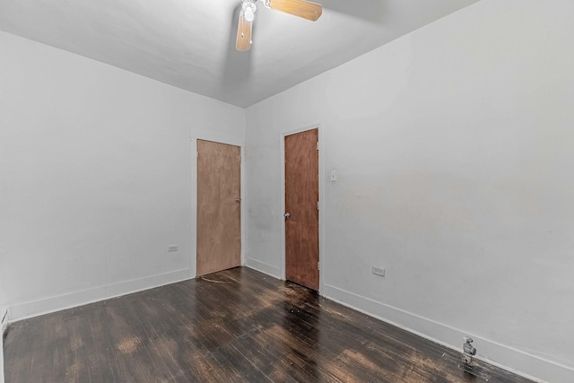 spare room with wood finished floors, a ceiling fan, and baseboards